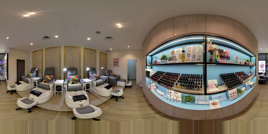 Interior view of a modern nail salon featuring pedicure stations and a vibrant product display.