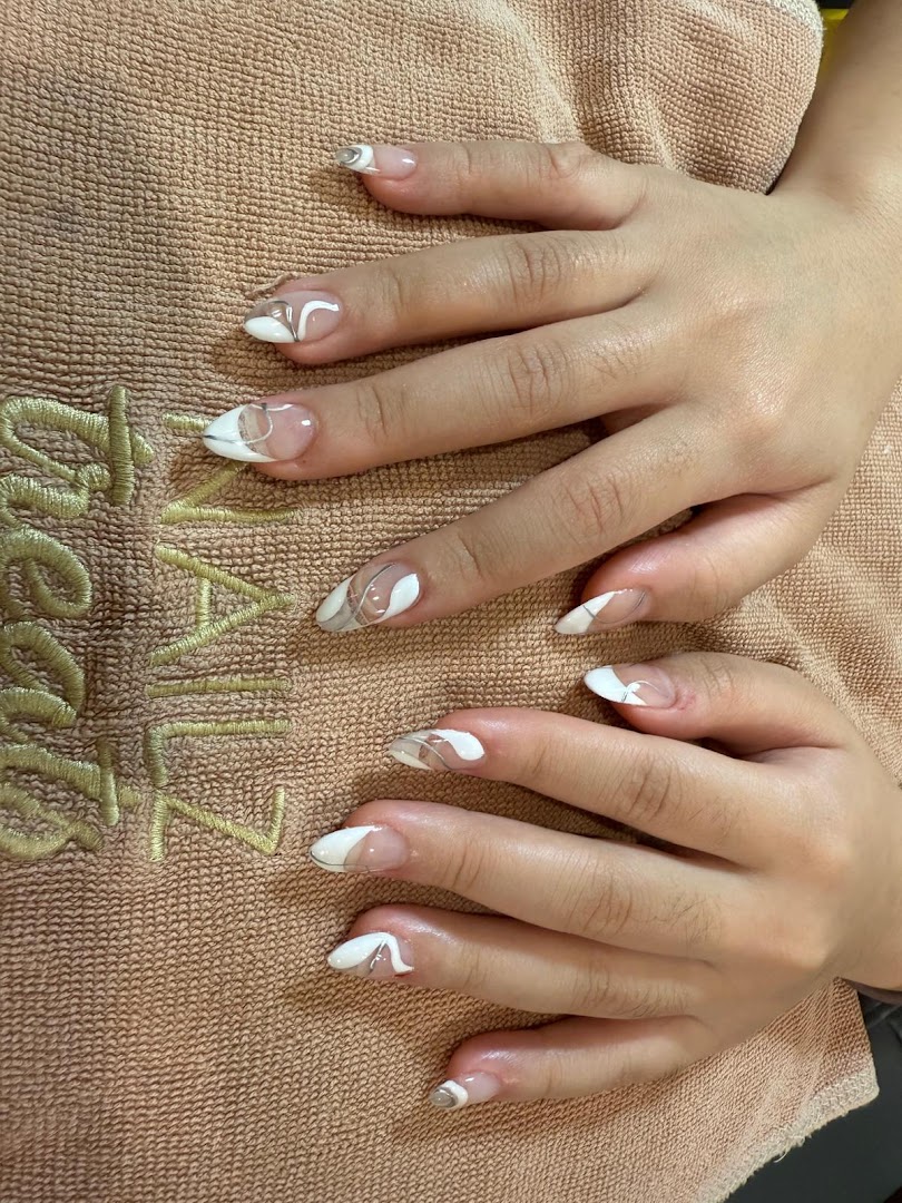 Close-up of hands showcasing a fresh, stylish nail art design with white and silver accents.