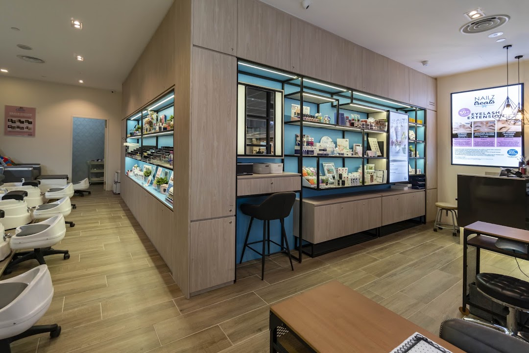 Bright and modern interior of Nailz Treats salon featuring pedicure stations and product display shelves.