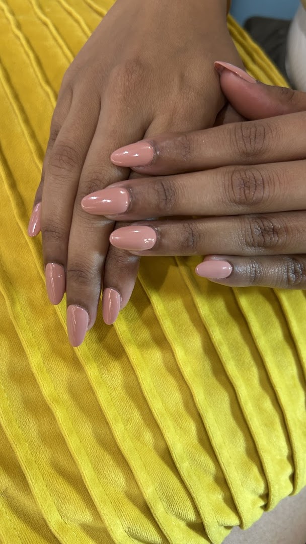 Close-up of hands showcasing a fresh manicure with elegant nude-colored nail polish.