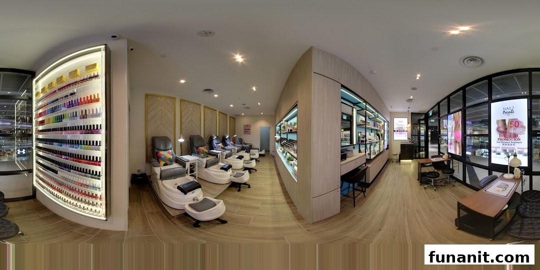 A panoramic view of a modern nail salon interior with pedicure chairs, nail polish displays, and manicure stations.