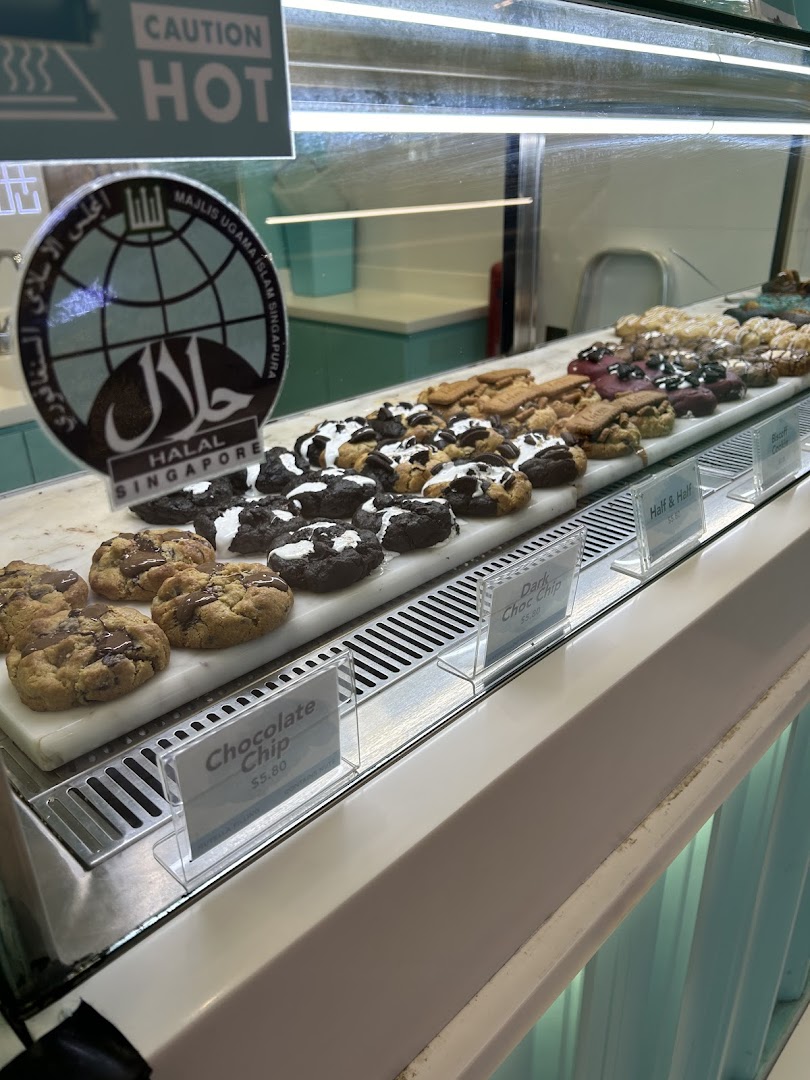 A display case showcasing a variety of freshly baked cookies with visible price tags.