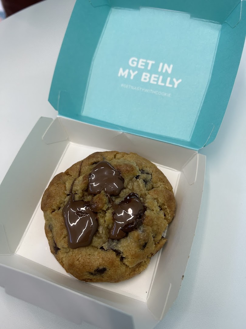 A delicious chocolate chip cookie with melted chocolate in a Nasty Cookie box.