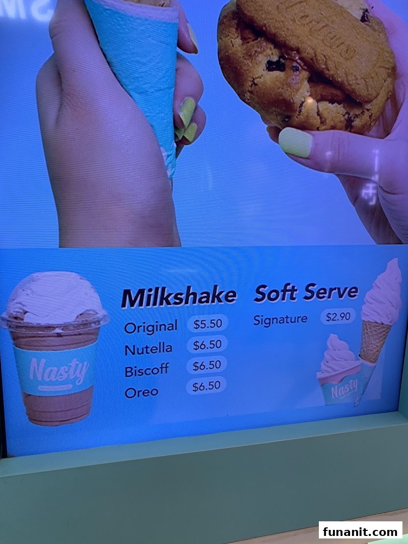 A digital menu board displaying milkshake and soft serve options with prices at Nasty Cookie.