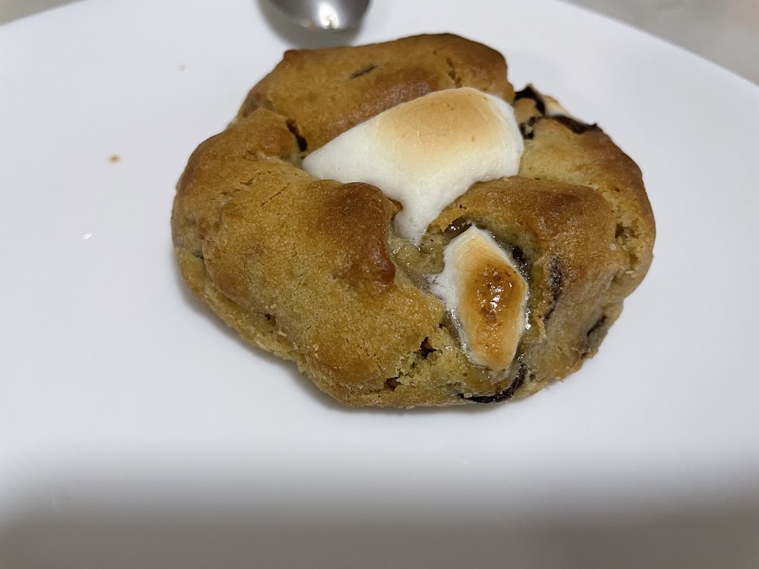 A close-up of a delicious Nasty Cookie, featuring a golden-brown cookie with melted marshmallows.