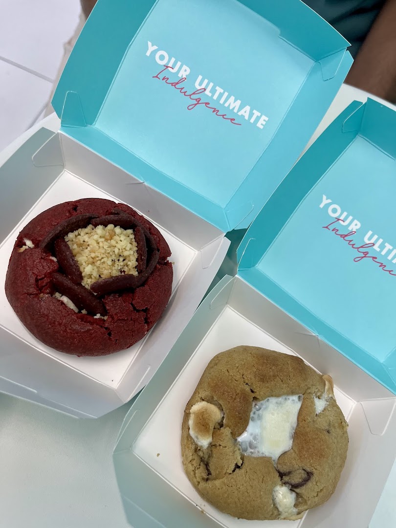 Two gourmet cookies, red velvet and chocolate chip, in branded boxes from Nasty Cookie.