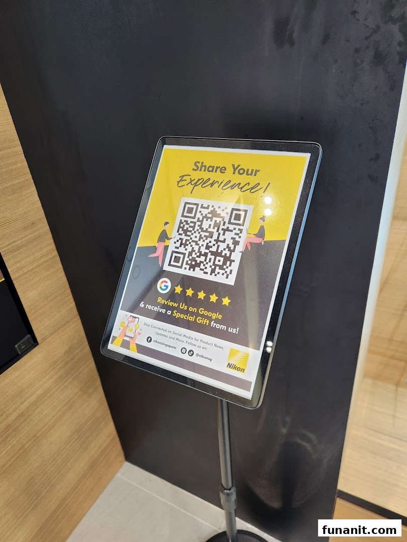 A stand-up sign inside the Nikon Experience Hub encouraging Google reviews and social media engagement.
