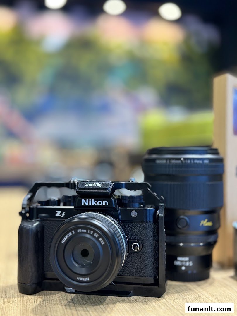 A close-up of a black Nikon Zf camera with a SmallRig cage and Nikkor Z 40mm lens.