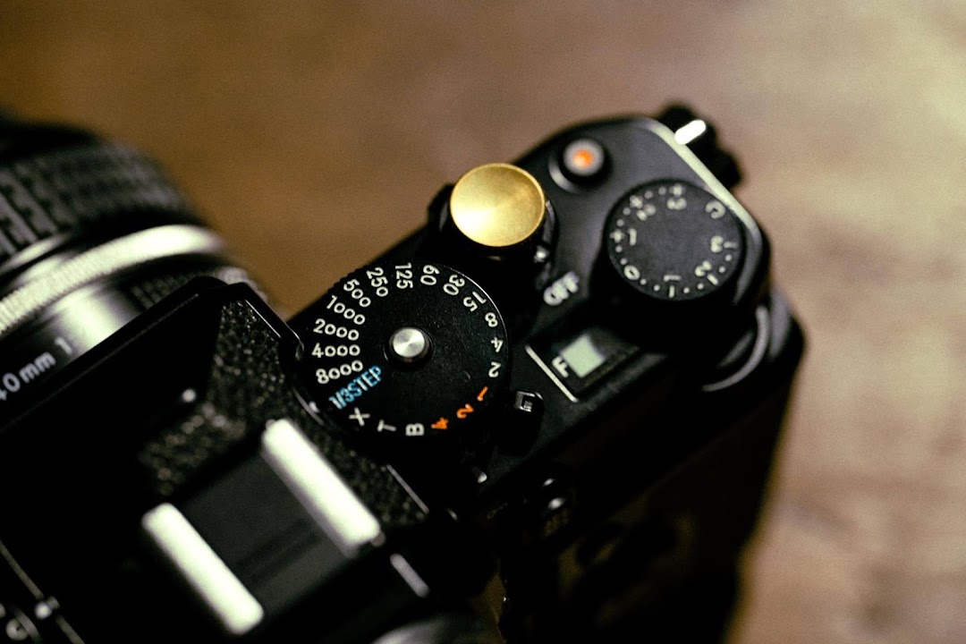 Close-up of a camera's top plate, showing shutter speed and exposure compensation dials.