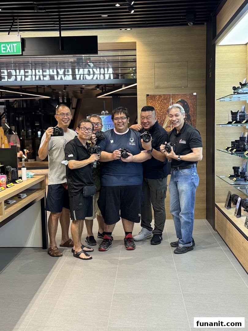 A group of smiling men holding cameras inside the Nikon Experience Hub Singapore.