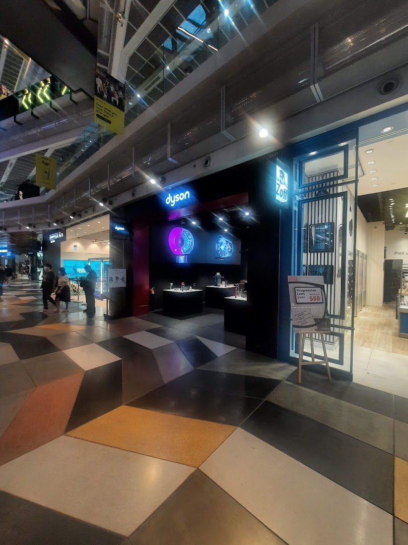 The image captures the illuminated entrance of a Dyson store, showcasing its innovative products, adjacent to Zoff eyewear.