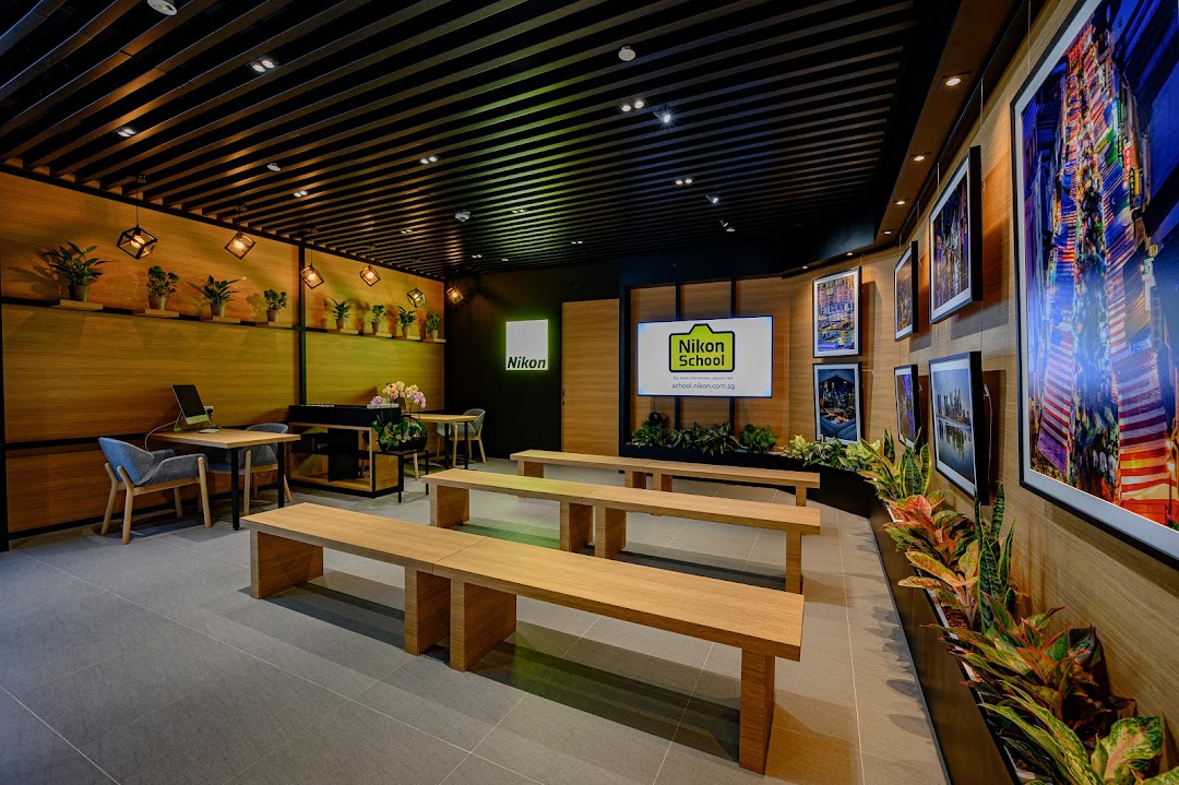 Interior view of Nikon Experience Hub, featuring a learning space with benches, tables, and photo displays.