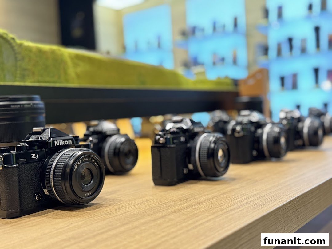 A row of sleek Nikon Z f cameras displayed on a wooden counter inside the Nikon Experience Hub.