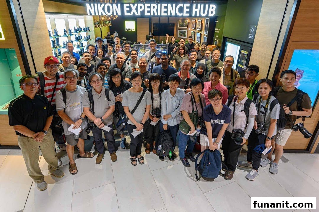 A large group of photography enthusiasts poses in front of the Nikon Experience Hub Singapore.