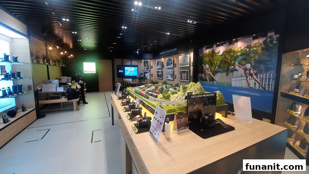 Interior view of Nikon Experience Hub, showcasing cameras, lenses, a model train display, and a photo gallery.