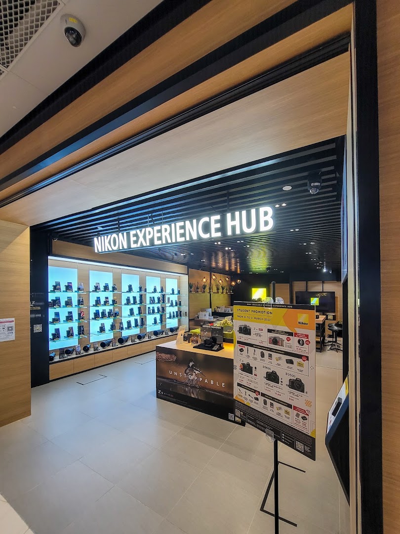 The entrance of the Nikon Experience Hub Singapore, showcasing cameras and accessories on display.