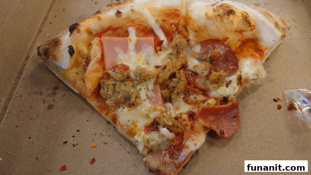 A close-up of a delicious, well-topped pizza slice resting in a cardboard box.