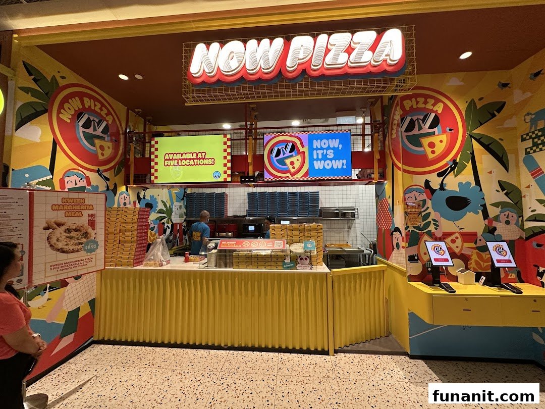 Vibrant Now Pizza shop front with a service counter and self-service kiosks.