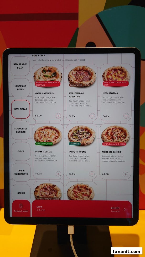 A digital menu display for Now Pizza, showcasing various pizza options and prices.