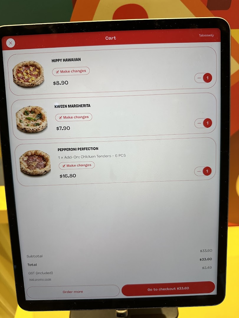 A digital ordering screen displaying pizza selections and prices in a cart.