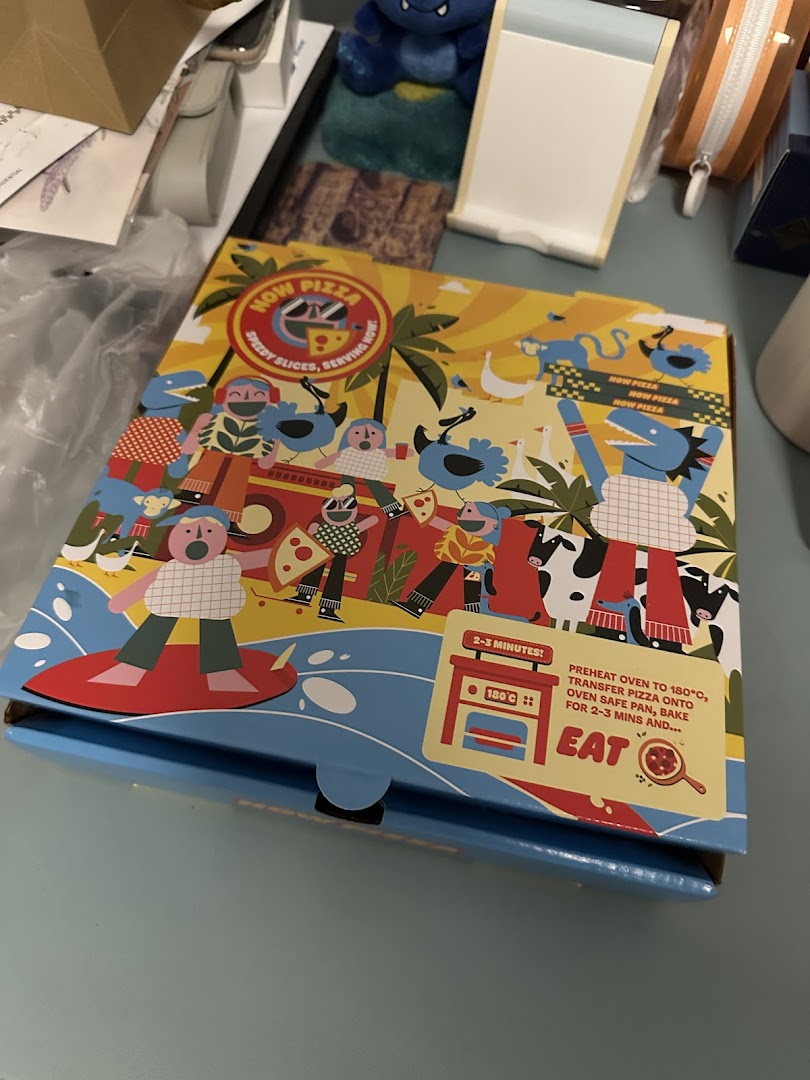 A colorful pizza box from Now Pizza with playful illustrations.