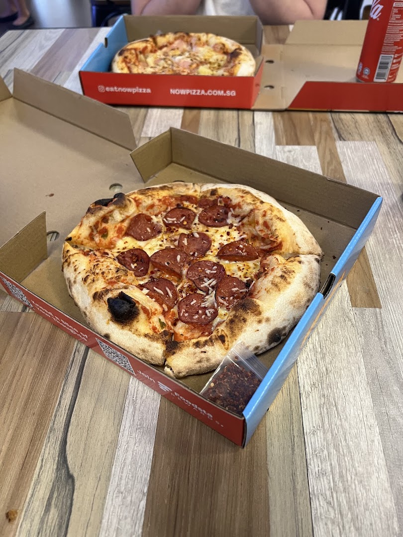 Two freshly baked pizzas in boxes, one pepperoni and one Hawaiian, ready to be enjoyed.