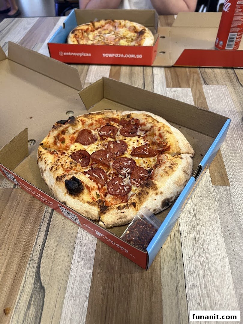 Two freshly baked pizzas in boxes, one pepperoni and one Hawaiian, ready to be enjoyed.
