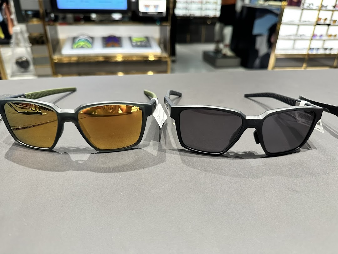 Two pairs of Oakley sunglasses, one with mirrored lenses, displayed on a counter inside the shop.