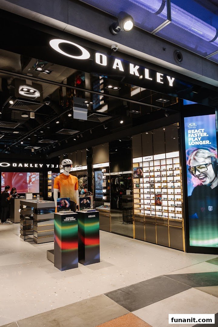 Interior view of the Oakley store, featuring eyewear displays, activewear on a mannequin, and a large digital screen.