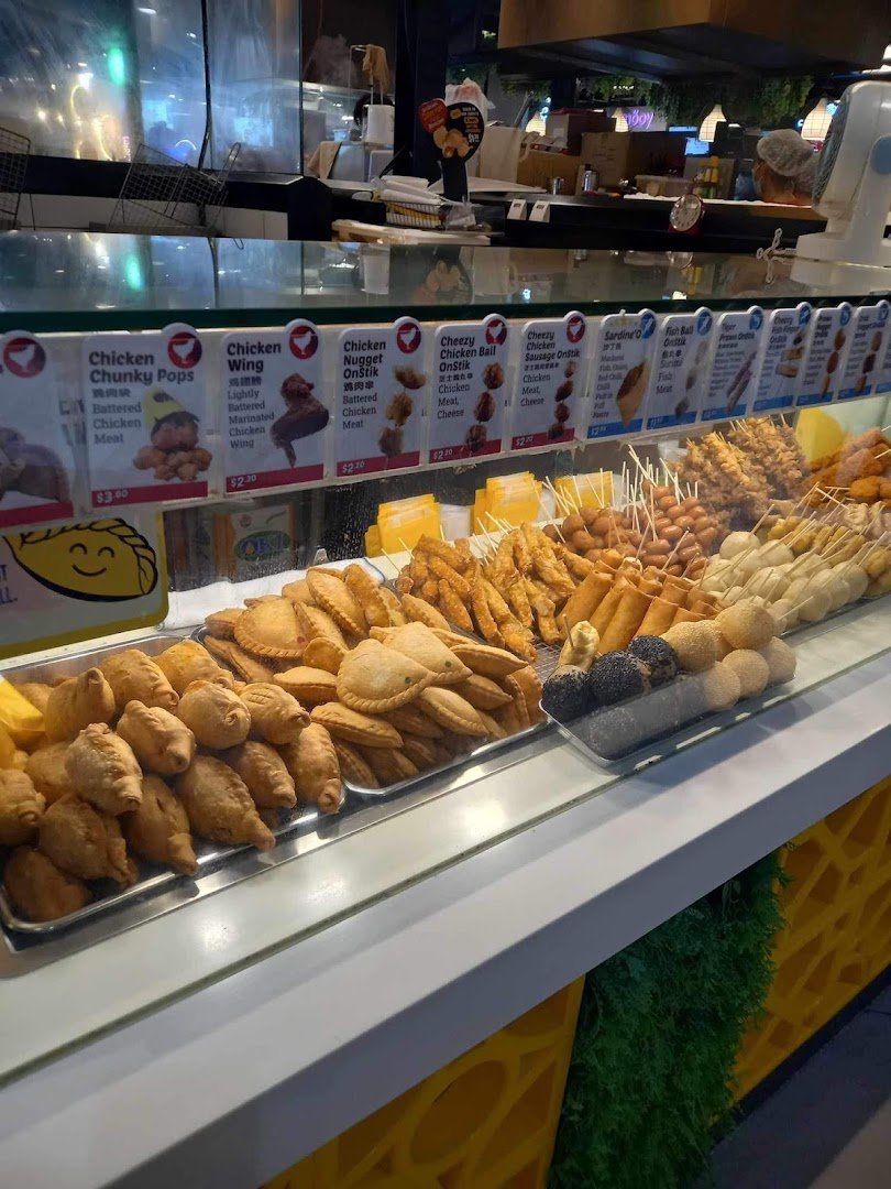 A vibrant display counter at Old Chang Kee showcasing a variety of fried snacks and menu items.