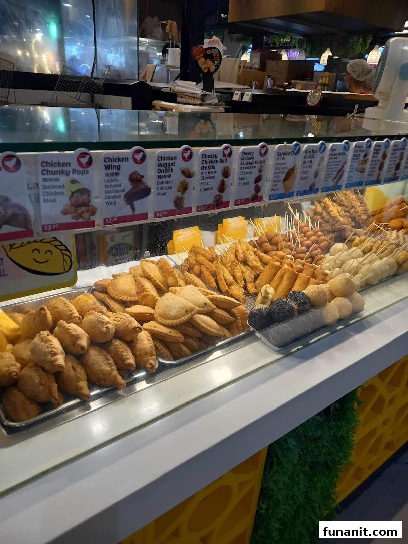 A vibrant display counter at Old Chang Kee showcasing a variety of fried snacks and menu items.