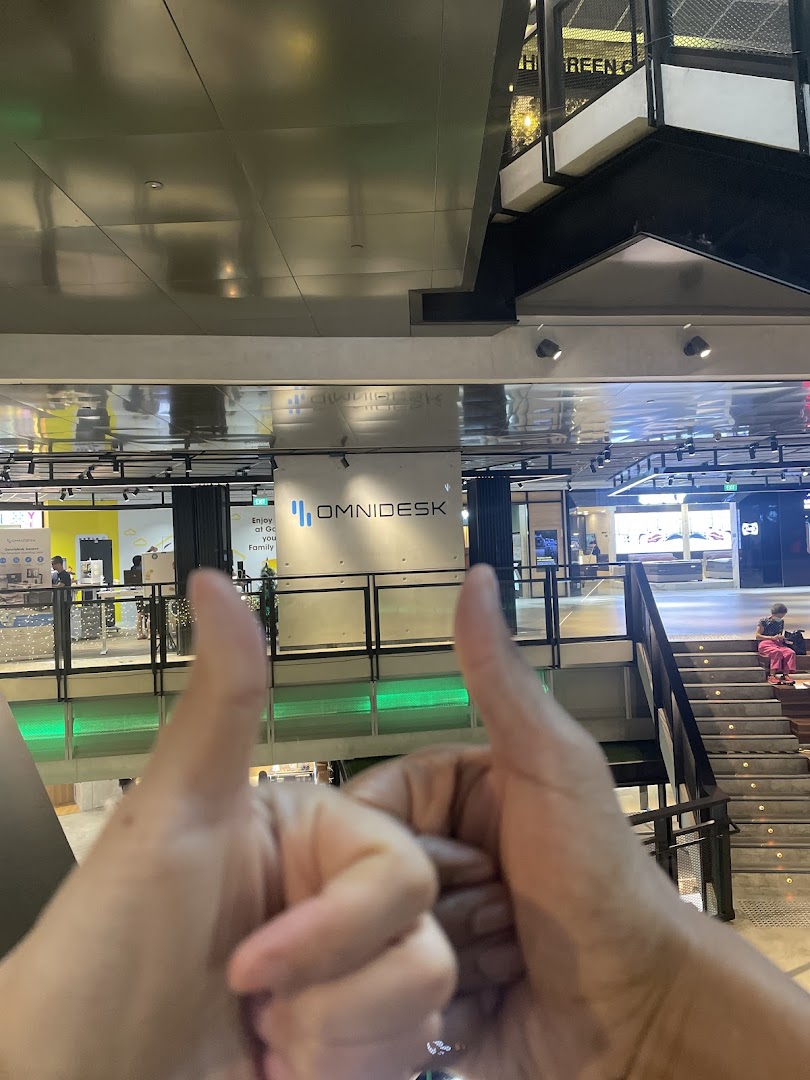 A view of the Omnidesk shop sign in Funan Mall, with hands giving a thumbs-up.