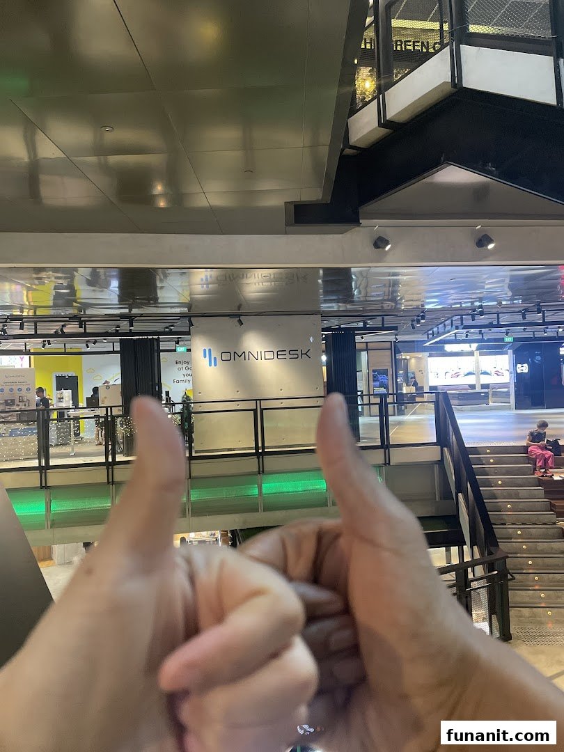 A view of the Omnidesk shop sign in Funan Mall, with hands giving a thumbs-up.