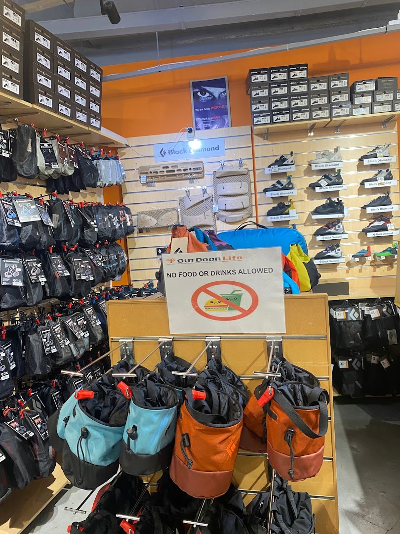 Interior view of Outdoor Life shop displaying climbing shoes, chalk bags, and various outdoor gear.