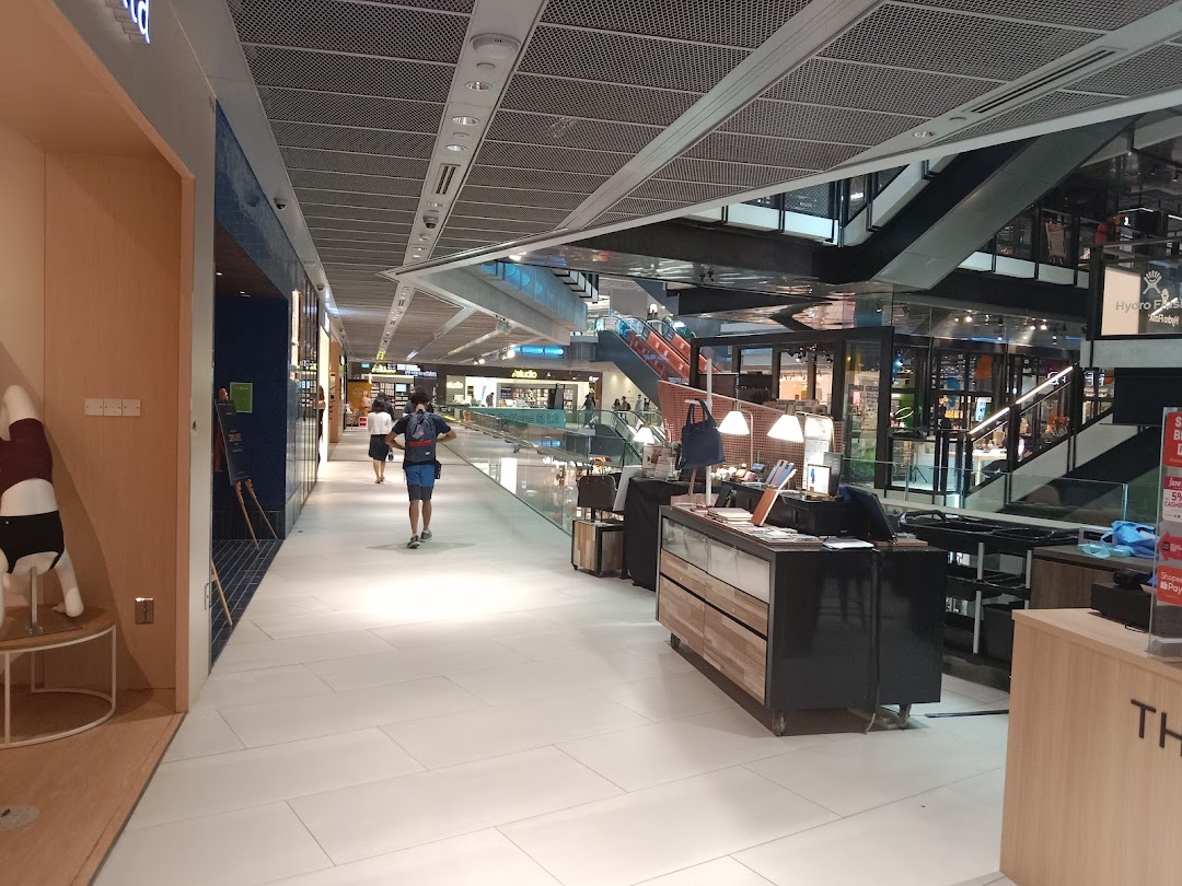 A mall interior showing a shop entrance, display, and shoppers in a bright, modern setting.