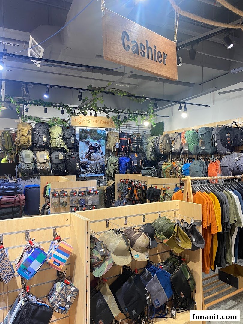 Interior view of Outdoor Life shop displaying a wide range of backpacks, apparel, and outdoor accessories.