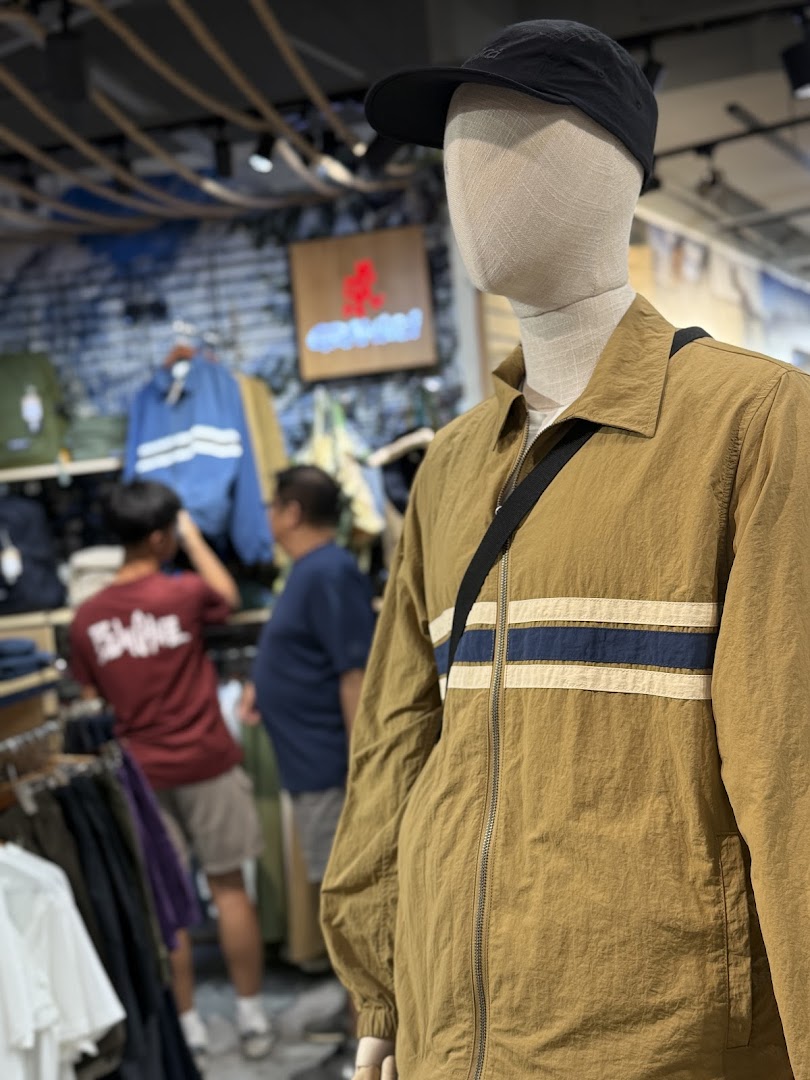 Mannequin displaying outdoor apparel inside Outdoor Life store, with customers browsing in the background.