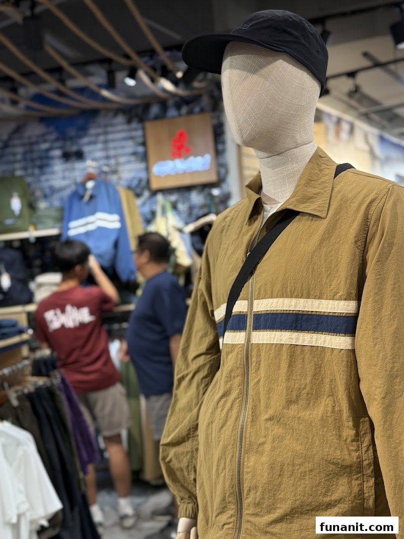 Mannequin displaying outdoor apparel inside Outdoor Life store, with customers browsing in the background.