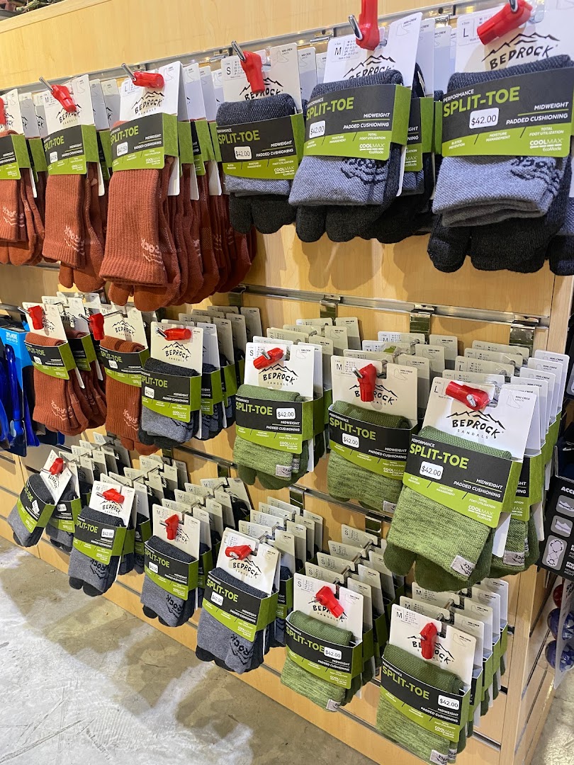 Rows of performance split-toe socks in various colors displayed on a retail shelf.