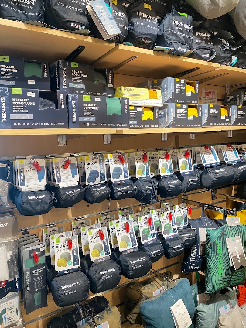 Shelves filled with Therm-a-Rest sleeping pads and pillows for outdoor adventures.