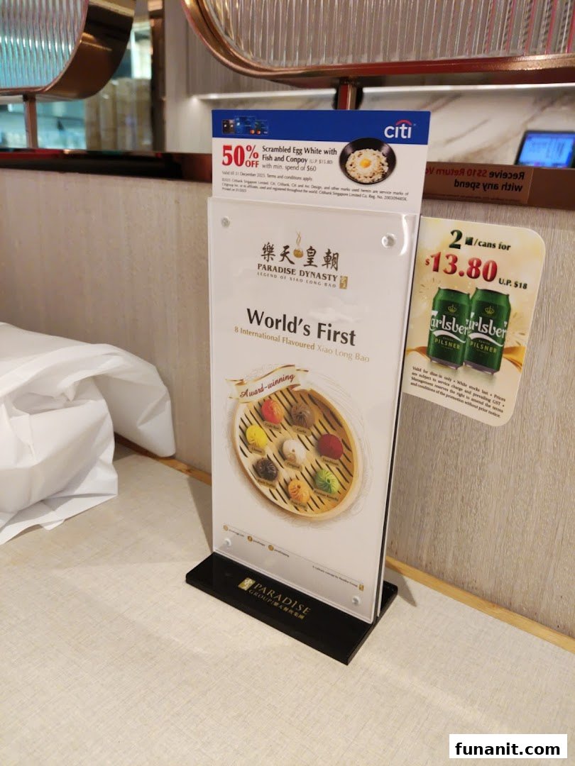 A table stand displaying Paradise Dynasty's signature 8-flavoured Xiao Long Bao and current promotions.