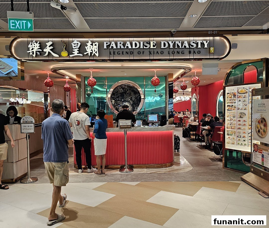 The vibrant entrance of Paradise Dynasty restaurant, featuring a red reception counter and dining area.