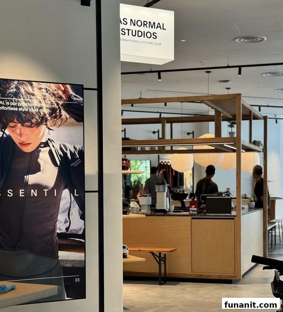 Interior view of Pas Normal Studios, featuring a counter, customers, and a large cycling apparel display.