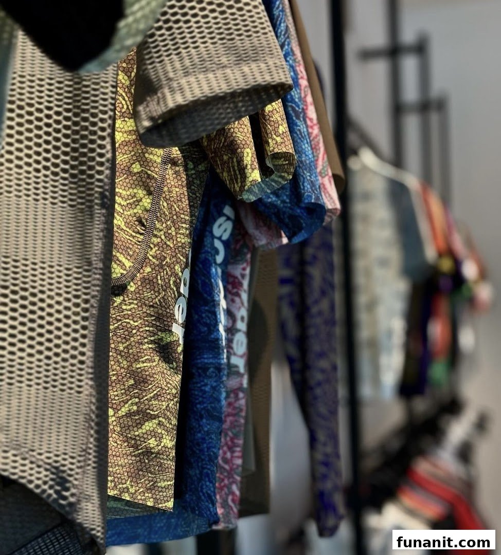Close-up of colorful, patterned cycling apparel hanging on a rack inside Pas Normal Studios.