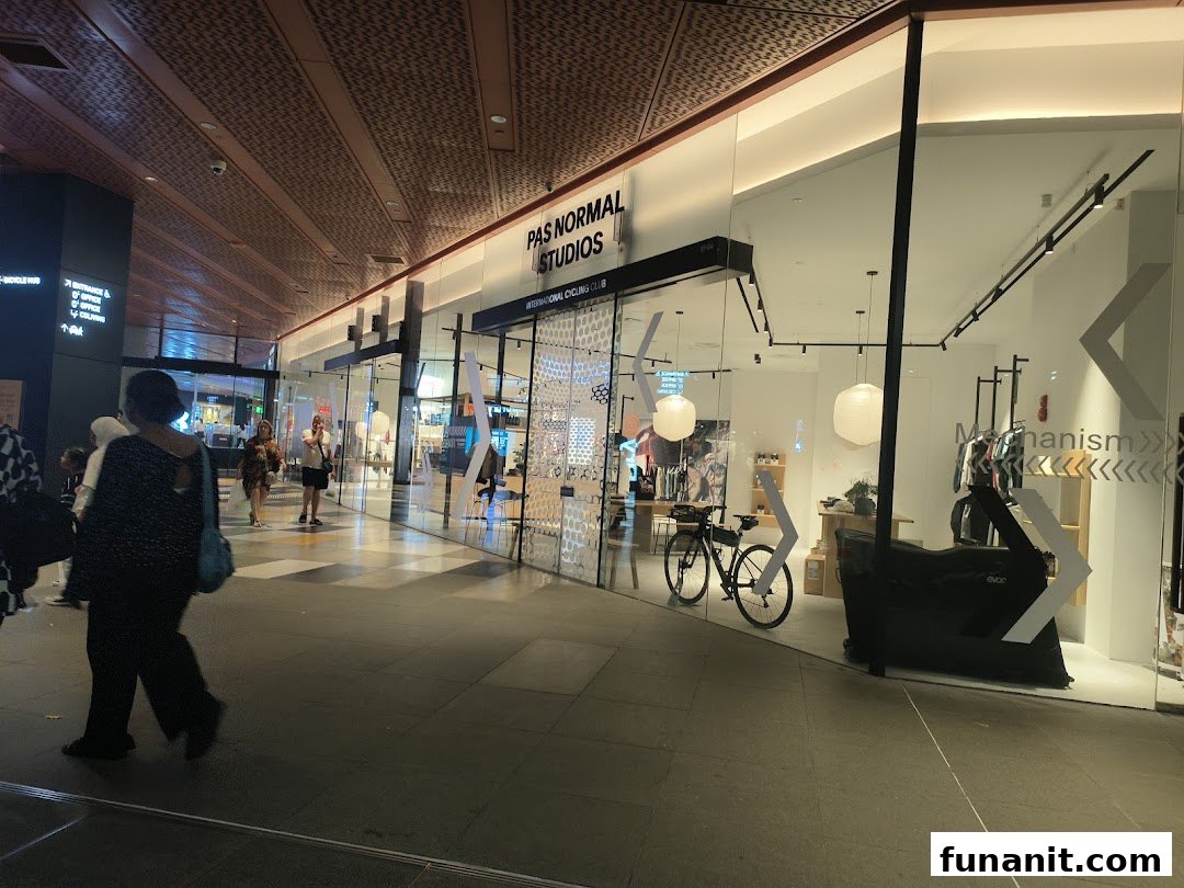 The shopfront of Pas Normal Studios, an international cycling club and apparel store, in a modern mall.
