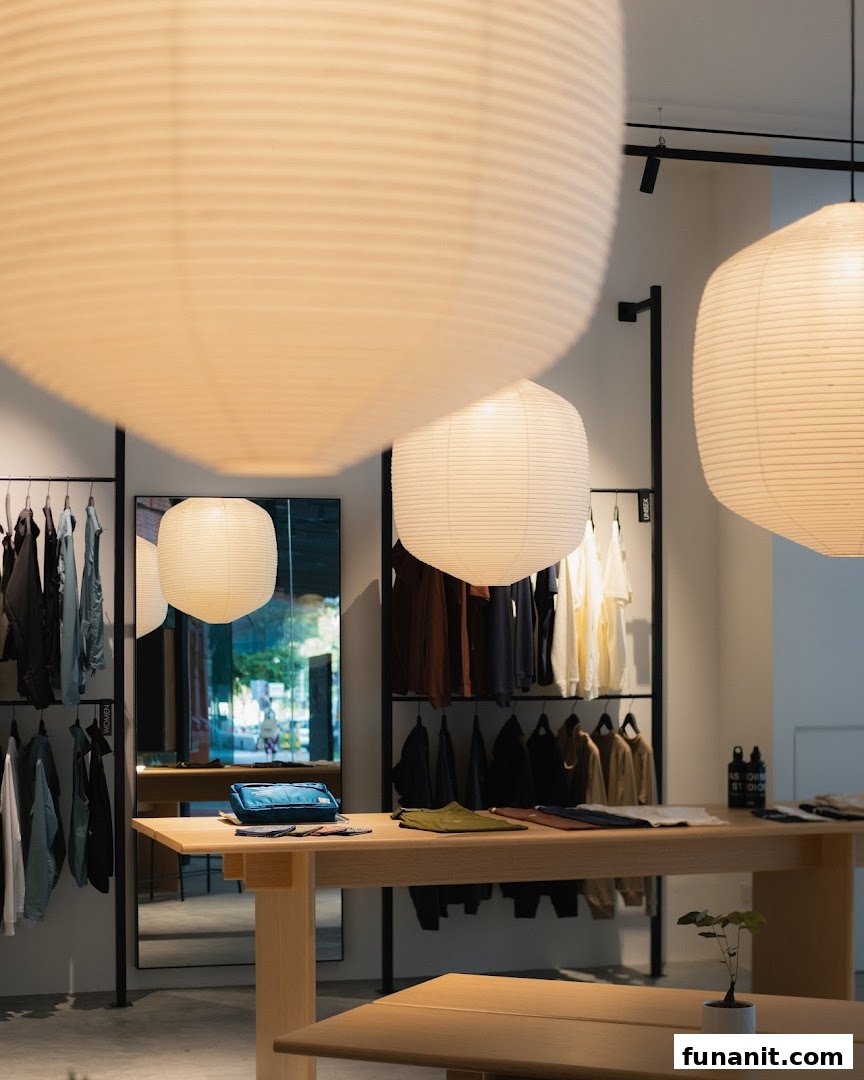 Interior view of Pas Normal Studios, showcasing minimalist design, clothing racks, and display tables with apparel.