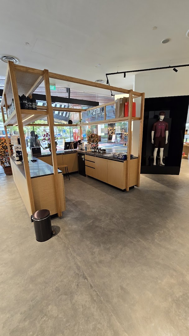 Interior view of Pas Normal Studios, featuring a modern counter, product displays, and a mannequin.