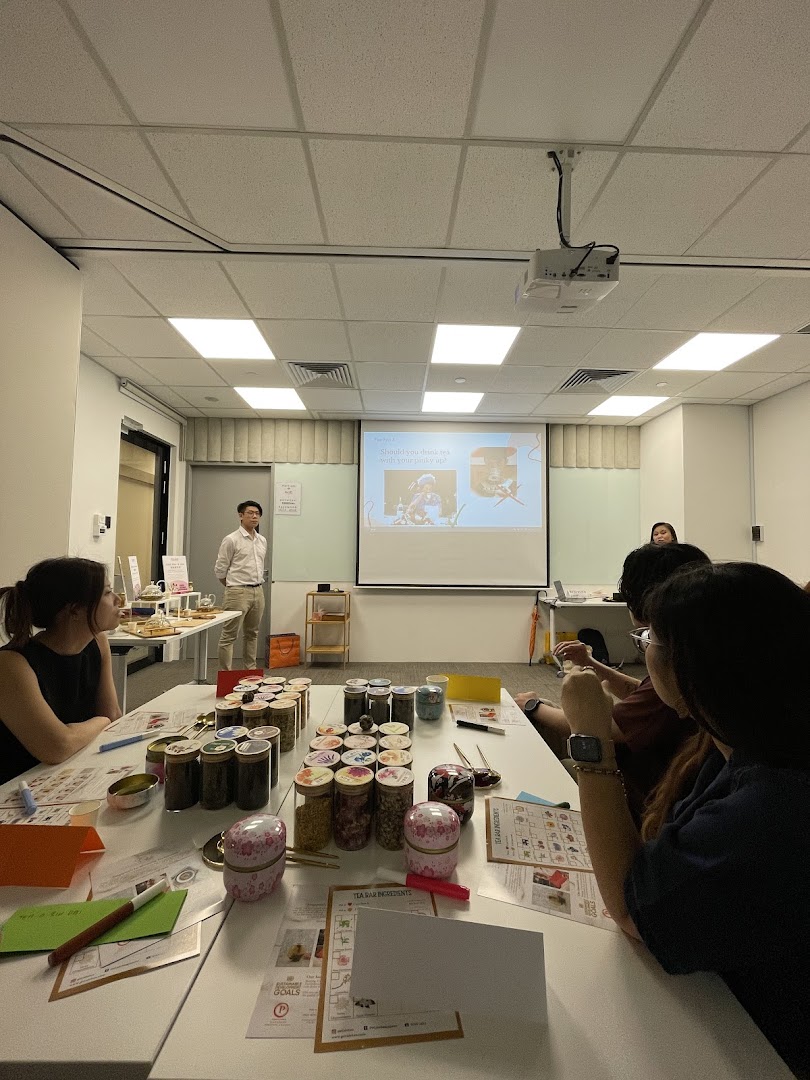 Attendees participate in a tea blending workshop with various ingredients and a presentation.