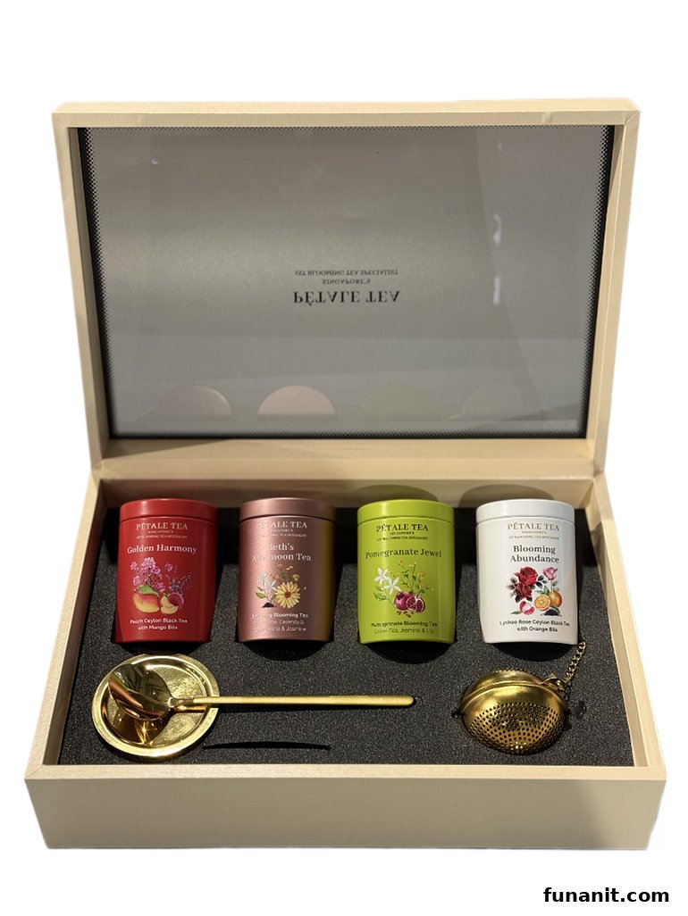 A beautifully presented Pétale Tea gift set featuring four tea tins, a golden spoon, and a tea infuser.