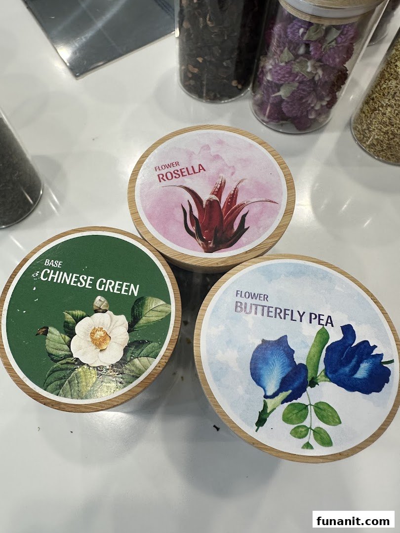 Three round containers displaying labels for Rosella, Chinese Green, and Butterfly Pea tea ingredients.